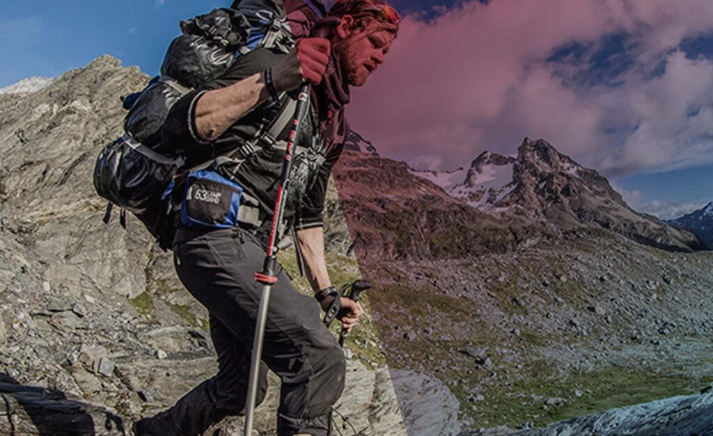 Ein Mann wandert mit Sportausrüstung in den Bergen